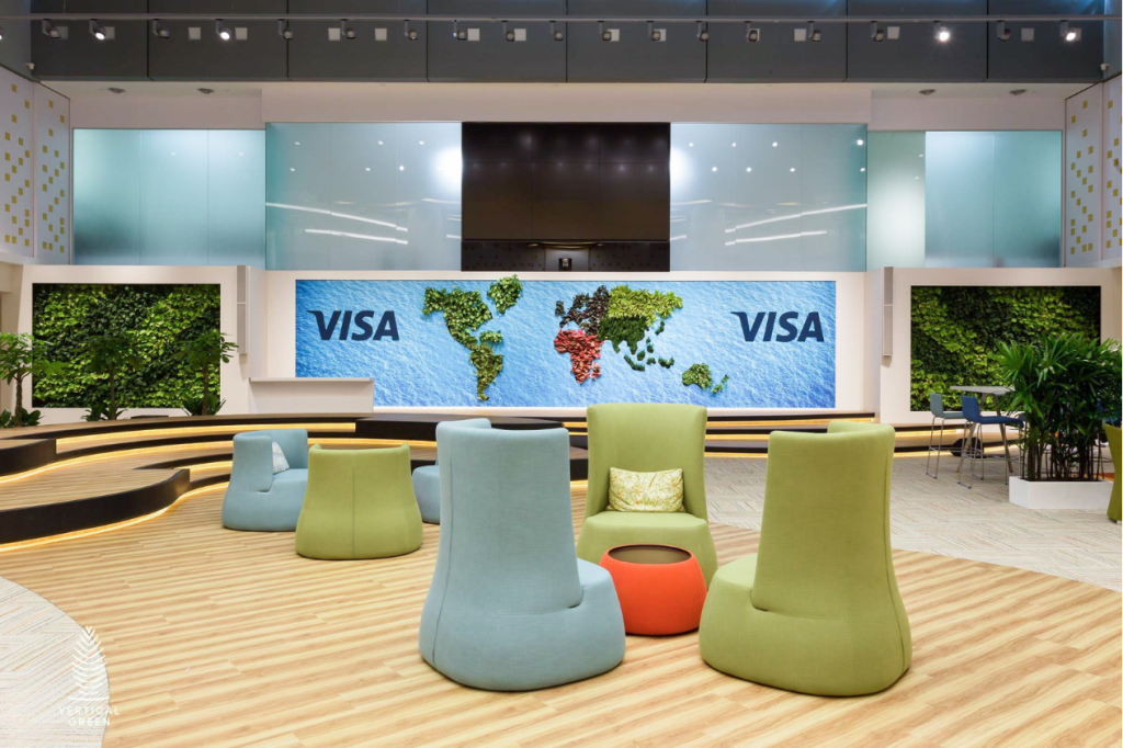 Modern corporate reception featuring a full-height living green wall, contemporary lounge seating, timber ceiling details and a bright office corridor.